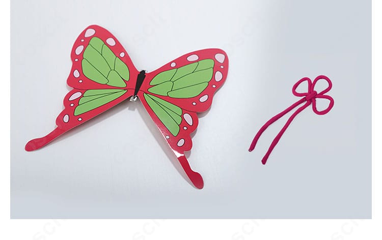 蝶モチーフの髪飾りと赤い紐飾りの近接写真。繊細な造形と色味の調和を表現。