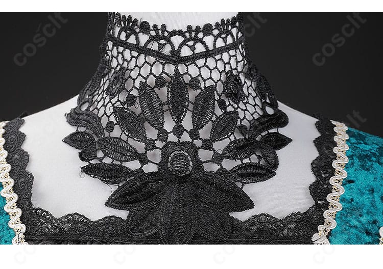 領口装飾アップ。首飾りとレースの重なり、エメラルド色のアクセントが映えるディテール画像