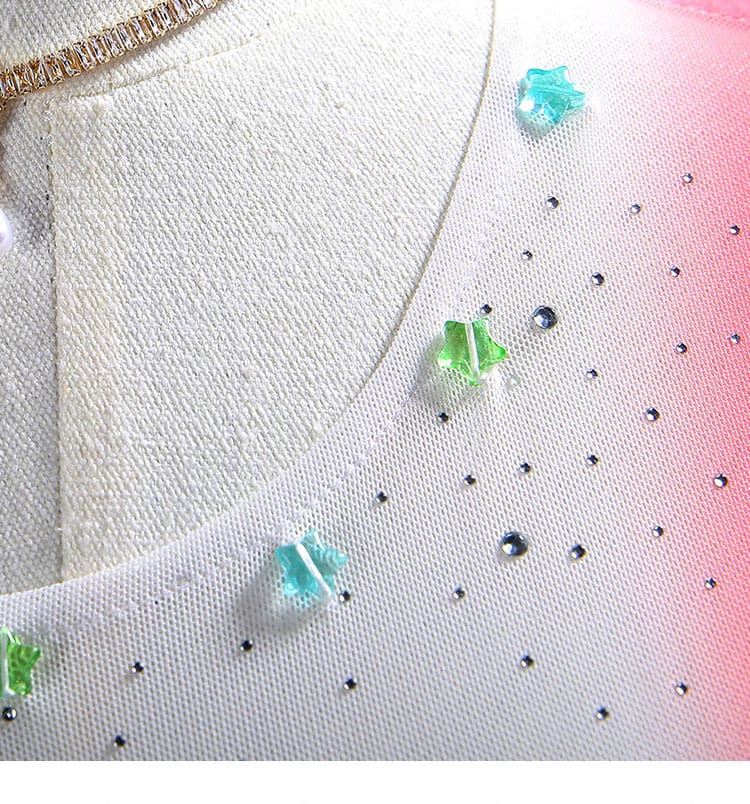 ドレスの襟元装飾ディテール。グリッターの輝きと生地の重なりを示す接写画像。