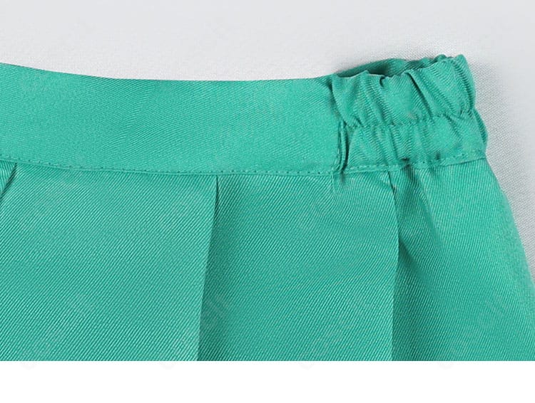 プリーツスカートの折り目とウエスト帯のディテール。均一なプリーツで脚長効果を狙える設計。